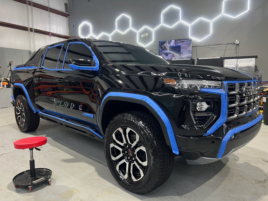 Black GMC Canyon masked off for paint correction and ceramic coating